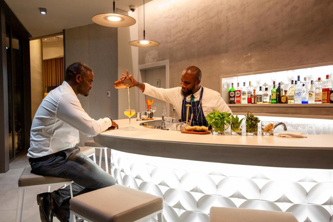 Noom Hotel Abidjan Plateau Exterior foto A bartender at work